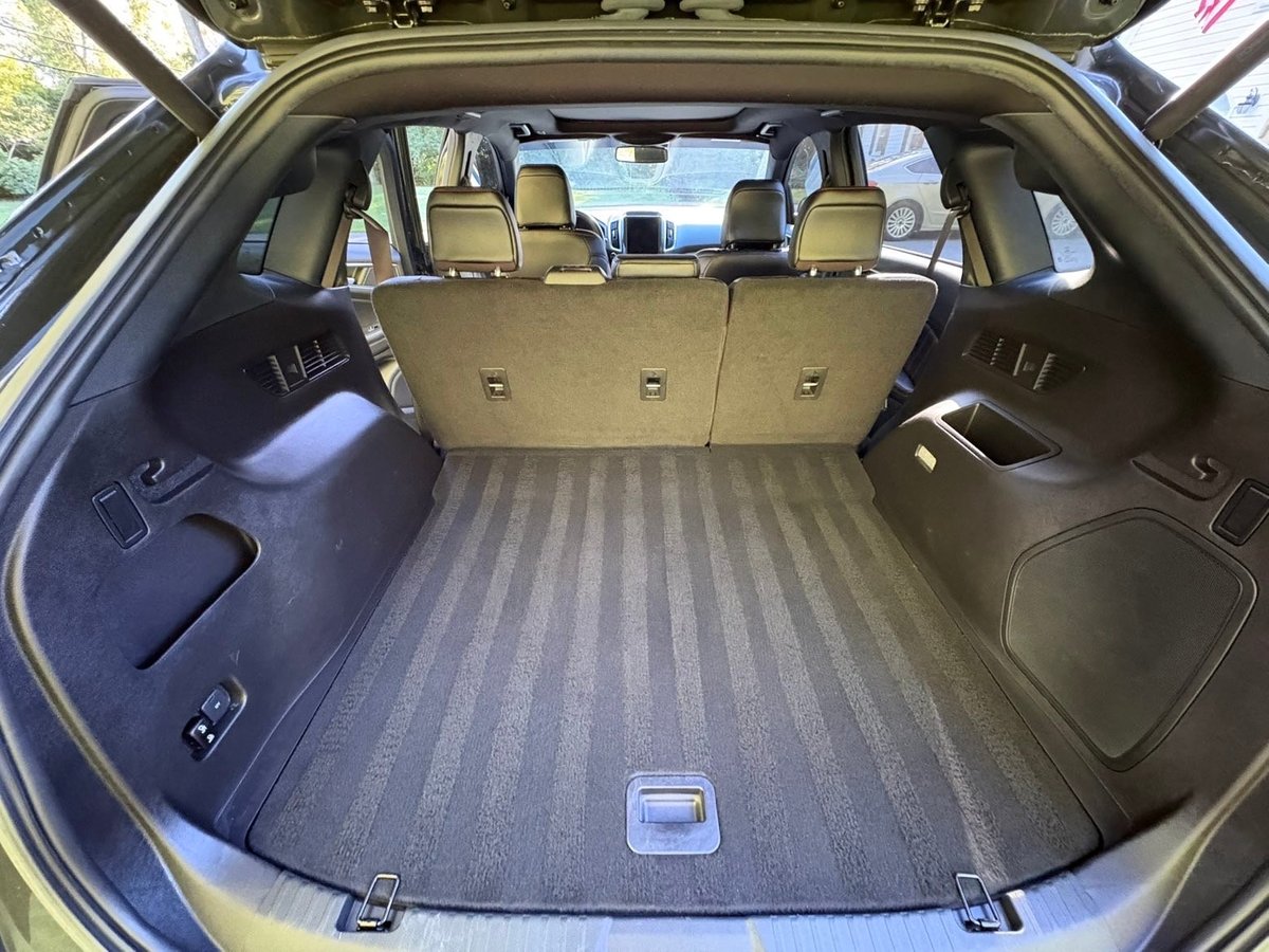 Empty car trunk with fold-down rear seats, carpeted cargo area, and interior visible through windshield